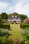 Lawned garden exterior of 1920s country house in Haslemere, Surrey, UK