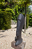 Large wooden head on gravel in garden of Haslemere home, Surrey, UK