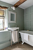 Hellgrün getäfeltes Badezimmer in einem Haus in Cirencester, Gloucestershire, Großbritannien