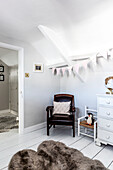 Vintage leather chair and bunting with soft fur rug in child's nursery Clevedon Somerset, UK