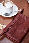 Red leather purse with Euro coins and cup and saucer, Majorca, Spain
