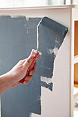 Man roller painting wall in UK home