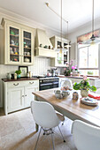 Small pendant lights hang above kitchen table with DSW chairs in Guildford home Surrey UK