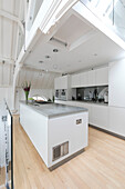 Open plan kitchen with polished concrete surfaces in converted Courthouse London UK
