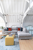Light grey sofa in open plan living room of converted London courthouse UK