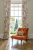 Upholstered velvet chair in window of Georgian Grade II listed Surrey home UK