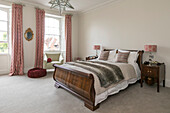 Polished wooden sleigh bed with fur throw in bedroom of Georgian Grade II listed Surrey home UK