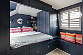 Built in bed with panelling and bookshelves in Victorian terrace Wandsworth London Uk
