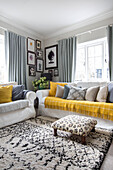 White sofas with grey and yellow soft furnishings in Guildford cottage Surrey UK