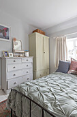 Light green quilt with painted furniture in Guildford cottage Surrey UK