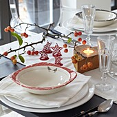 Christmas place setting with lit candle in British home, UK