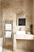 Cream marble wash stand with basin and wall mounted radiator