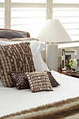 Braune Kissen auf dem Bett mit Lampe in einem Haus in Sydney Australien