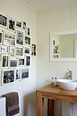 Wall display of family photographs in bathroom of Bembridge farmhouse, Isle of Wight, England, UK