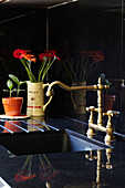 Vintage mixer tap with cut flowers on draining board in London kitchen, England, UK