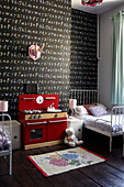Toy kitchen with alphabet wallpaper in child's room of London home, England, UK