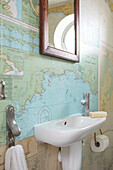 Cloakroom with navigational charts and mirror above basin Isle of Wight, UK