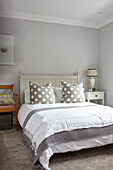 Spotty cushions on colonial style bed in light greys Buckinghamshire UK