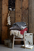 Rustic charm blankets and cushion on stool with wood cladding and garlic