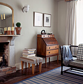 Corner of country style living room with ottoman bureau and chaise