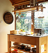 Modern country kitchen detail with freestanding wooden workbench and pan rack