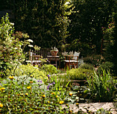 English summer garden with pond and garden furniture