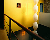 Blick vom Balkon in ein offenes Wohnzimmer mit skulpturaler Papierbeleuchtung