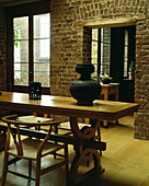 Dining room with Hans Wegner wishbone chairs and exposed brick wall