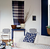 Blaues und weißes Wohnzimmer mit Polsterkissen aus Inlettstoff und Blumenkissen
