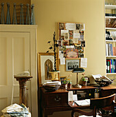 Desk and chair with pin board and assorted paperwork in home study