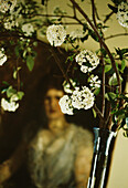 Detail of Burkwood Viburnum branch in vase with oil painting in background