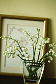 Detail of lily of the valley in glass vase on shelf
