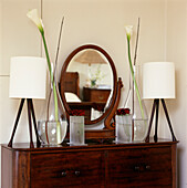 Close up of antique dressing table with oval mirror and arum lilies