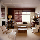 Comfortable living room in neutral tones with wooden Venetian blinds