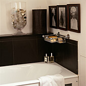 Black slate wall tiles in bathroom with vase full of bottles and pictures on wall