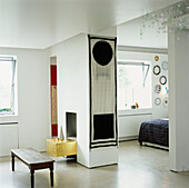 Weißes Schlafzimmer mit zentralem Kamin mit Blattgoldverzierung und Wandbehängen
