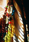 Detail of colourful silk tassels with oriental beads on a curtain tie back in a window