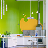 Hellgrüne und gelbe Küche in einem umgebauten Industriegebäude