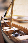 Small wooden toy sailing boat with canvas sail