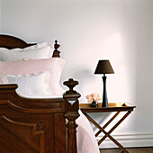 Close up of vintage wooden bed and bedside table and lamp