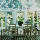 Wintergarten mit weiß lackiertem Esstisch und Stühlen im Shaker-Stil