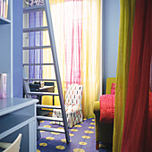 Blue girl's bedroom with upholstered chairs and sheer curtains