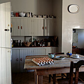 Rustikale Küche mit Tisch aus Kiefernholz, Einbauschränken und Stalltür