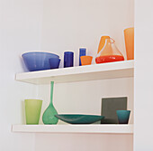 Zeitgenössische, farbenfrohe Glassammlung auf weißen Regalen