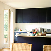 Black modern fitted kitchen diner with garden views