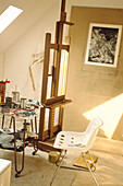 Working artist's studio in attic with large easel and unfinished sketches