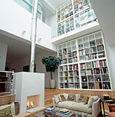 Large contemporary open plan white living room with open shelving storage space modern fireplace and mezzanine