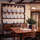 Antike walisische Kommode aus Holz mit dekorativen Tellern und Tisch und Stühlen im Stil der fünfziger Jahre im Esszimmer