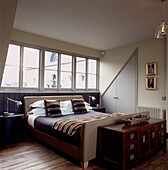 Stilvolles Schlafzimmer mit Doppelbett in einer Dachgaubenaussparung