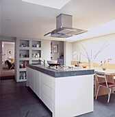 Kitchen island with stainless steel extractor fan with boxed shelving unit in modern kitchen